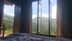 a bedroom with a window with a view of a mountain at Trekker's Lodge in Matale