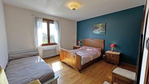 a bedroom with two beds and a blue wall at Le gîte de montréal in Saint-Germain-les-Belles