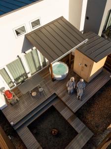 two people standing on a deck with a toilet at 軽井沢一棟貸しBBQサウナつき別荘- YURAGI - TSUKI me CHILL in Miyota