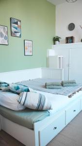 a white bed with pillows on it in a room at Le Cocon Bressan hyper centre & lumineux in Bourg-en-Bresse