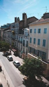 a city street with cars parked in front of buildings at Le Cocon Bressan hyper centre & lumineux in Bourg-en-Bresse