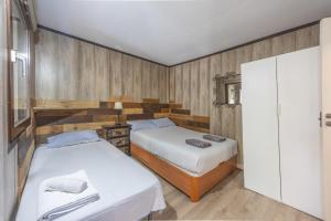 two beds in a room with wooden walls at Sunwaves 4 - Casa Duna in El Palmar