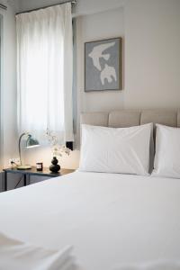 a bedroom with a white bed and a window at NIMA Mytikas Apartments - Aitoloakarnania in Mitika +92 photos