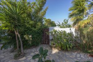 a gate in a garden with trees and plants at Sunwaves 4 - Casa Duna in El Palmar
