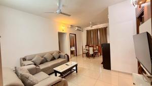 a living room with a couch and a tv at Krishna Cottage 3BR Apt By Amoret Homes in Chicalim