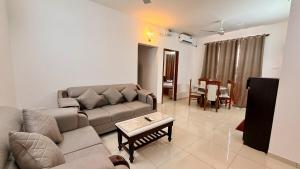 a living room with a couch and a table at Krishna Cottage 3BR Apt By Amoret Homes in Chicalim
