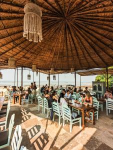 a group of people sitting at tables under an umbrella at Alpa Viram Retreat Goa in Mandrem