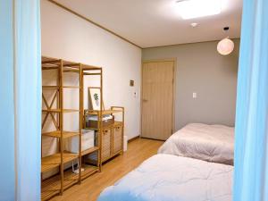 a bedroom with two beds and a book shelf at 마음스테이 in Taesuha-dong