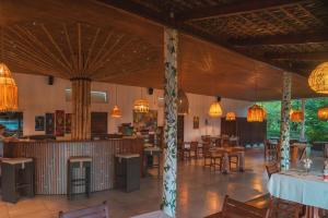 a restaurant with tables and chairs and chandeliers at Belamandy Lodge Hotel au luxe simple in Anjramarango