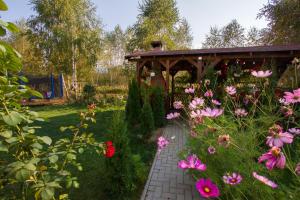 a garden with a wooden gazebo and flowers at Royal Hotel in Drăguş