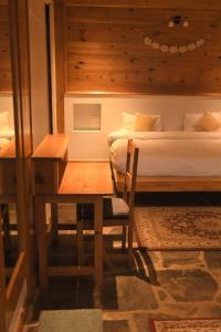 a bedroom with a bed and a table and a desk at Kainchi Boutique Homestay in Rāmgarh