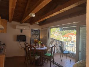 a dining room with a table and chairs and a window at Ducina Apartments in Milna +45 photos