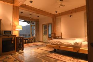 a bedroom with a bed and a television in a room at Kainchi Boutique Homestay in Rāmgarh