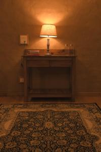 a table with a lamp on top of a rug at Kainchi Boutique Homestay in Rāmgarh