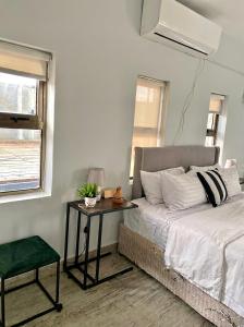 a bedroom with a bed and a table next to a window at White house Residences by Pebbles in Lusaka +18 photos