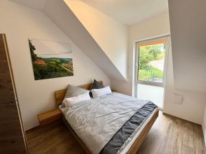 a bedroom with a bed and a large window at Ferienwohnanlage Einzigartig in Saarburg