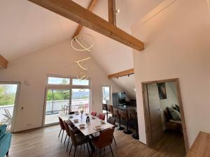 a dining room and living room with a table and chairs at Ferienwohnanlage Einzigartig in Saarburg