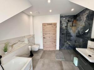 a bathroom with a shower and a toilet and a sink at Ferienwohnanlage Einzigartig in Saarburg +237 photos