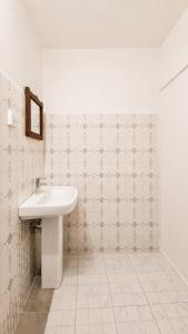 a bathroom with a sink and a tiled wall at Serene Abodes in Zanzibar City