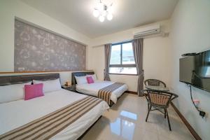 a hotel room with two beds and a tv at Rain Sun Homestay in Ji'an