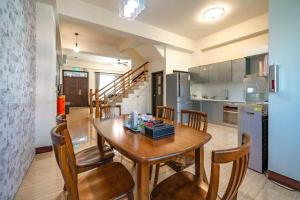 a kitchen and dining room with a wooden table and chairs at Rain Sun Homestay in Ji'an