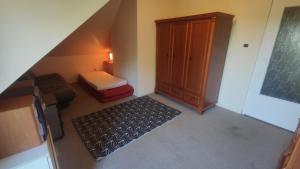 an attic room with a bed and a cabinet and a rug at Vikos-Spa in Rzeczyca
