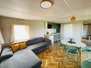 a living room with a couch and a table at Mobilheim Luna - Výrovická přehrada in Výrovice +5 photos