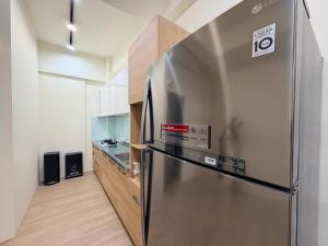 a kitchen with a stainless steel refrigerator in a room at Si Sou Homestay in Nanxi