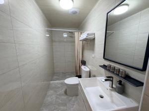 a bathroom with a sink and a toilet and a mirror at Si Sou Homestay in Nanxi