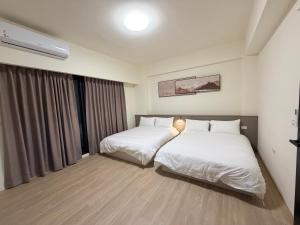 a hotel room with two beds and a window at Si Sou Homestay in Nanxi