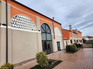 an orange and white building with an arched window at Residence Oasi del Delta in Taglio di Po