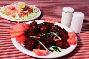 马尼帕尔Hotel Ashlesh Manipal的桌子上两盘食物