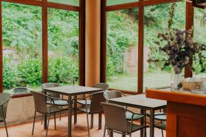 two tables and chairs in a room with windows at Hotel EntreRobles in Baiona +63 photos