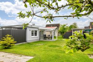 a backyard of a house with a grass yard at Lütte Auszeit in Hennstedt