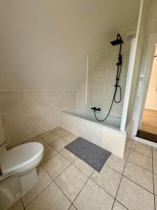 a bathroom with a shower and a toilet and a tub at Het Schuttershof in Hoogstraten