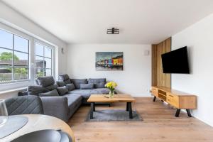 a living room with a couch and a tv at Lütte Auszeit in Hennstedt