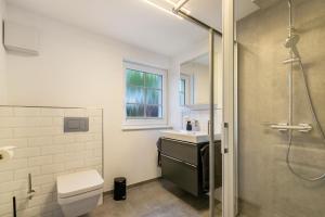 a bathroom with a shower and a toilet and a sink at Lütte Auszeit in Hennstedt +19 photos