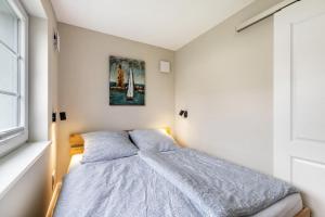 a bedroom with a bed and a painting on the wall at Lütte Auszeit in Hennstedt