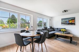 a living room with a table and chairs and a couch at Lütte Auszeit in Hennstedt