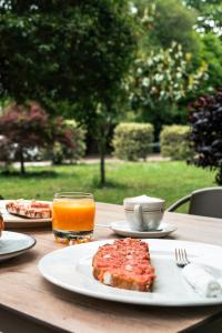 a table with a plate of food and a glass of orange juice at Hotel EntreRobles in Baiona