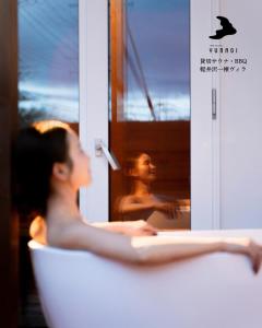 a woman sitting in a chair in front of a mirror at 軽井沢一棟貸しBBQサウナつき別荘- YURAGI - TSUKI me CHILL in Miyota