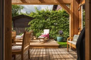 a wooden patio with chairs and a gazebo at Das Heinz Altaussee - Your Austrian Home in Altaussee