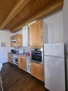 a kitchen with a white refrigerator and wooden cabinets at Casetta gialla in Brianza - Monticello Brianza - NON E' CASATENOVO in Casatenovo