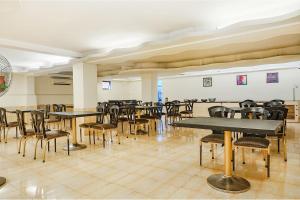 a dining room with tables and chairs in it at FabHotel Golden Emerald in Pune