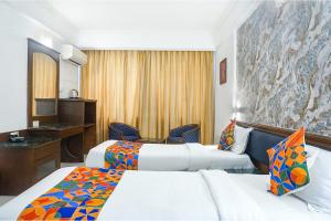 a hotel room with two beds and a desk at FabHotel Golden Emerald in Pune +39 photos
