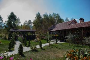 a garden with a pavilion and a house at Royal Hotel in Drăguş