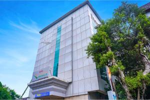 a building with a blue stripe on the side of it at FabHotel Golden Emerald in Pune