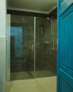 a glass shower in a bathroom with a blue door at Lemon Garden Türkbükü in Türkbükü +25 photos