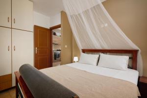 a bedroom with a bed with a mosquito net above it at Chara Stone House in Kharasón