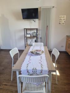 a dining room table with chairs and a table cloth at Casetta gialla in Brianza - Monticello Brianza - NON E' CASATENOVO in Casatenovo